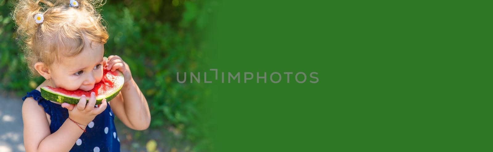 A child eats watermelon in the park. Selective focus. Kid.