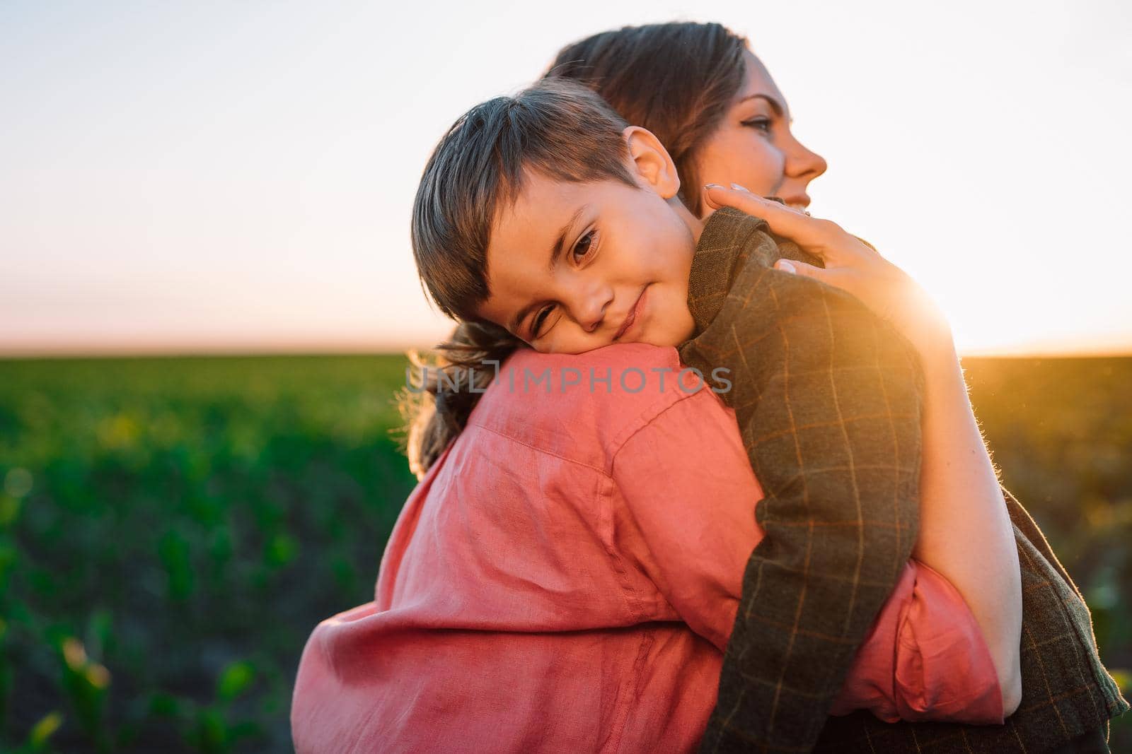 Loving smiling son hugs mom tightly. Tender family scene. Cute 3 year old ukrainian kid with mother. Parenthood, childhood, happiness, children wellbeing concept. High quality photo