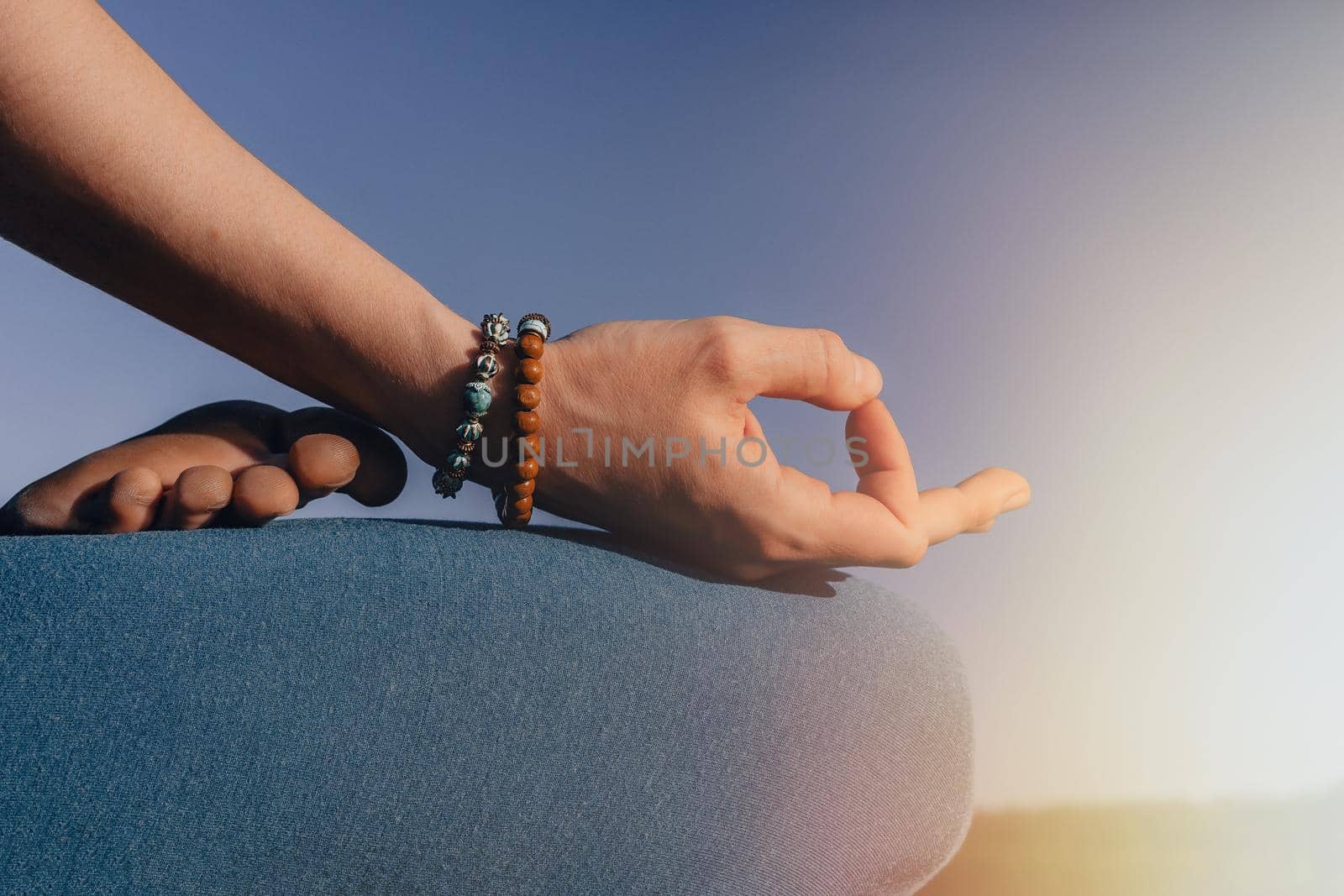 Healthy woman sitting in lotus pose and meditating on high cliff above river. Calm yoga concept, zen, relaxation, practice on nature background. by kristina_kokhanova