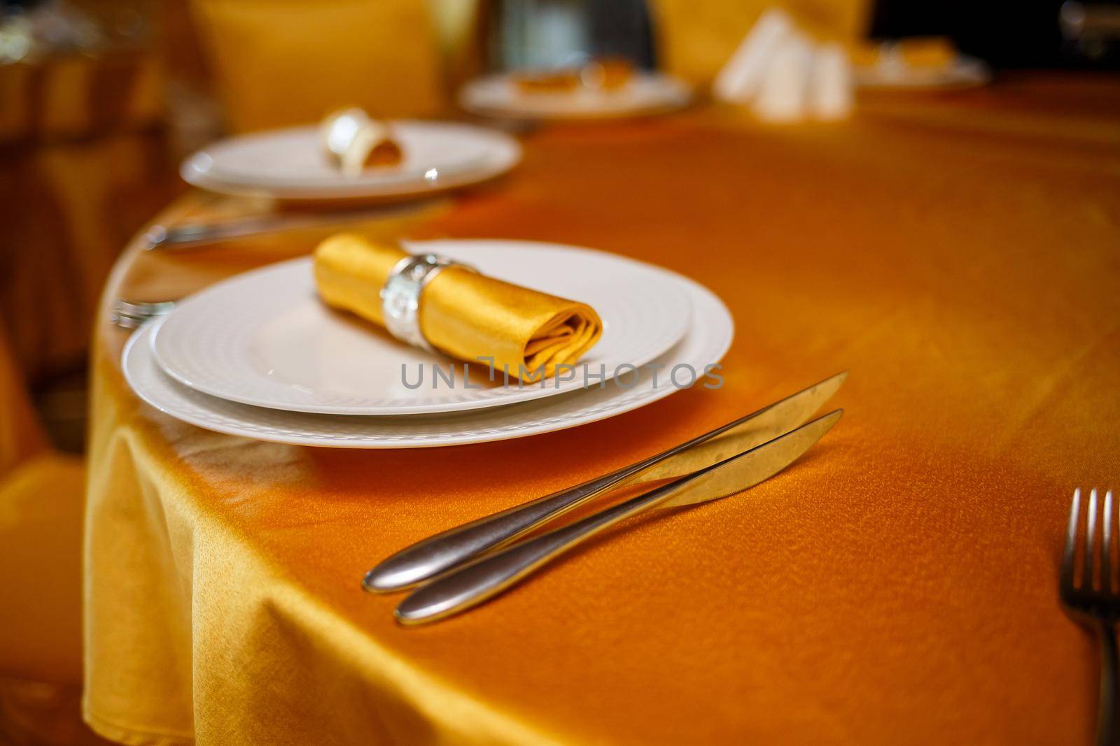 Elegant table setting with fork, knife and gold napkin