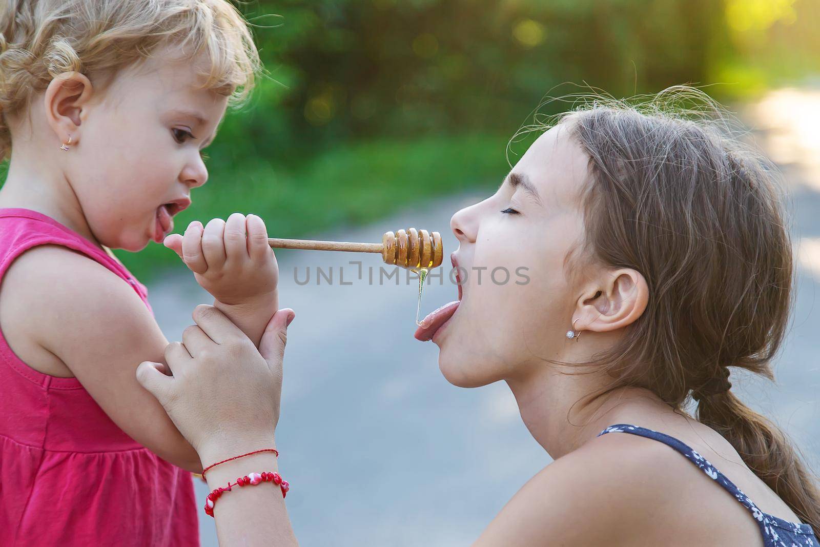 A child eats honey in the park. Selective focus. by yanadjana