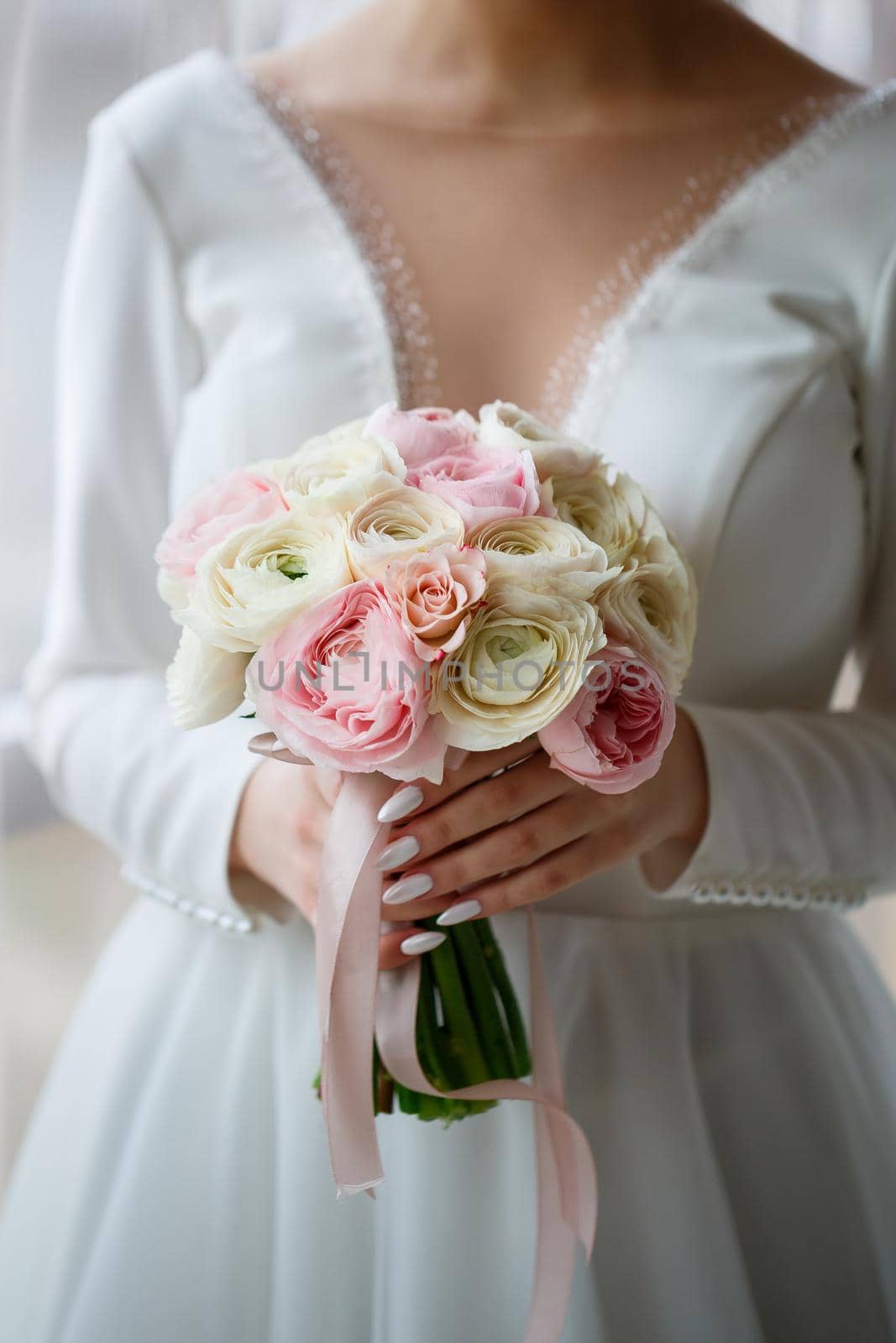 Bride in white dress holds a bouquet of flowers