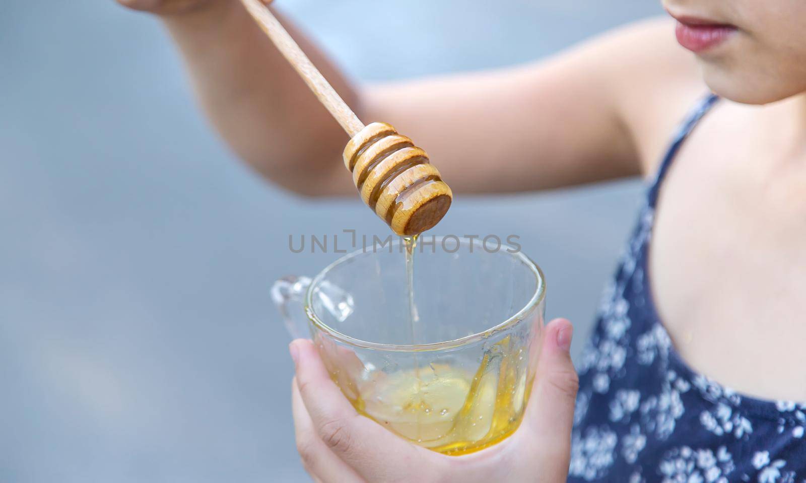 A child eats honey in the park. Selective focus. by yanadjana