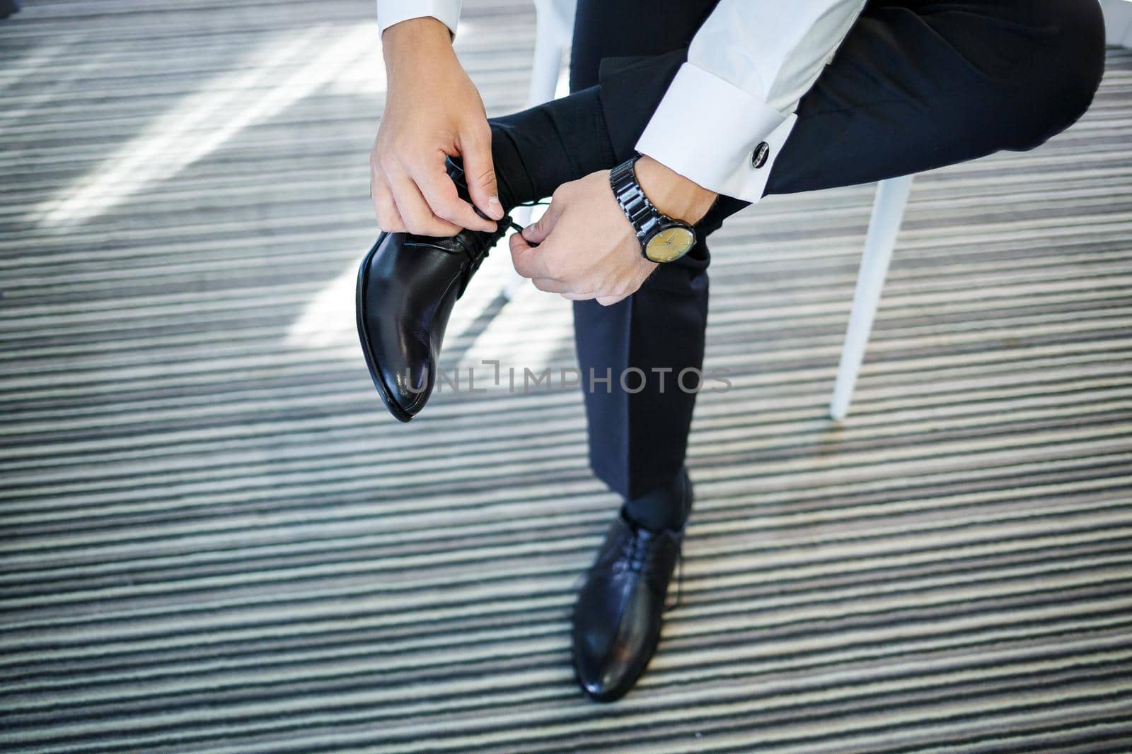 man puts on a suit on the wedding day