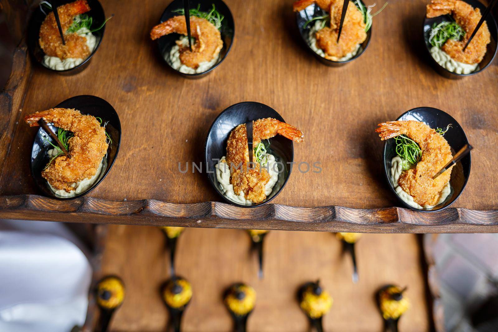 Beautifully decorated banquet table with various seafood appetizers and sandwich and shrimp appetizers
