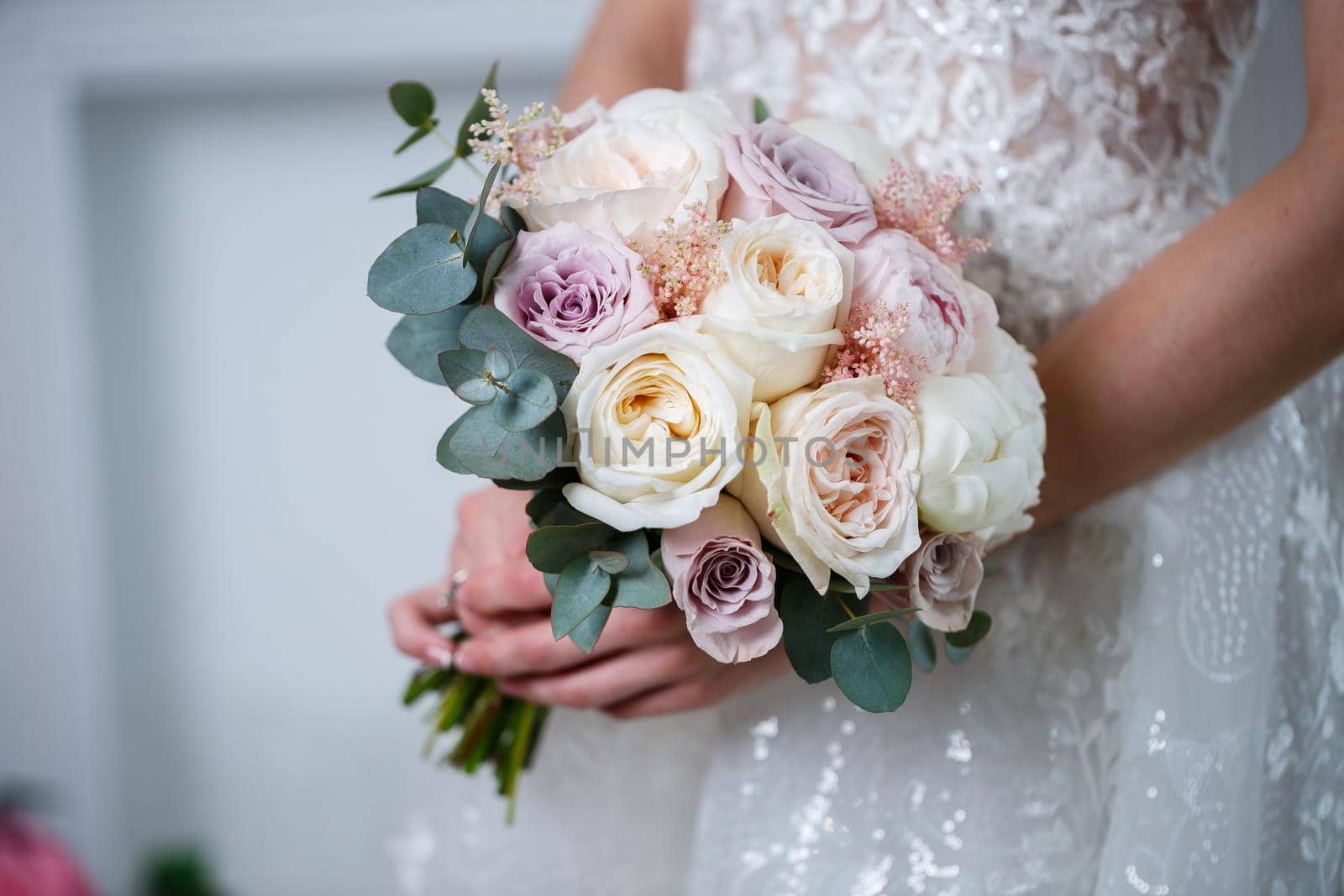 Beautiful wedding bouquet of flowers in the hands of the newlyweds by Dmitrytph