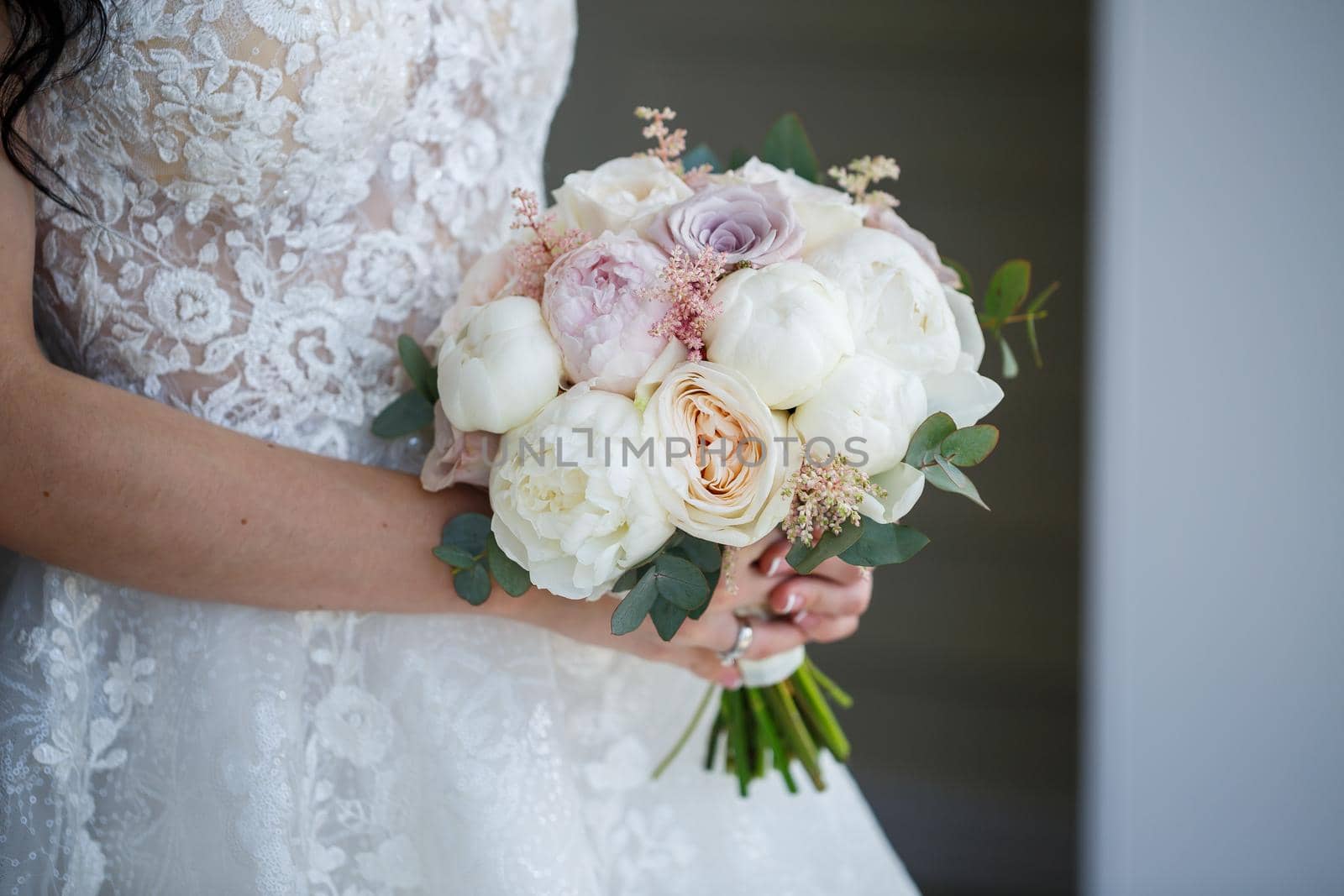 Beautiful wedding bouquet of flowers in the hands of the newlyweds