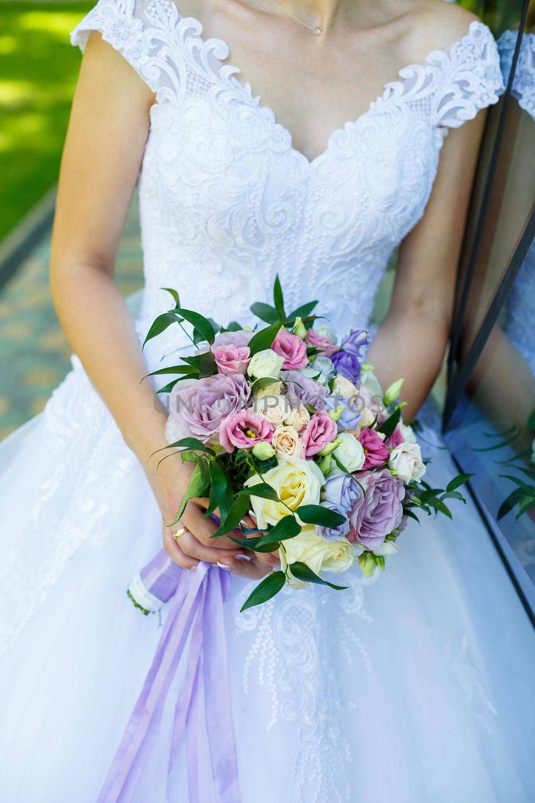 Beautiful wedding bouquet of flowers in the hands of the newlyweds by Dmitrytph