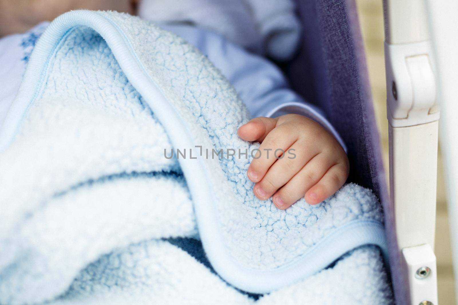 Baby hand on a white coverlet