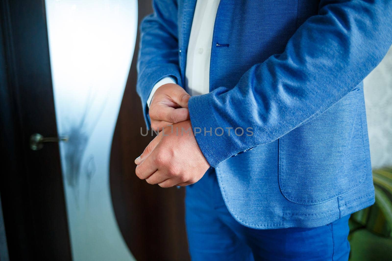man puts on a suit on the wedding day