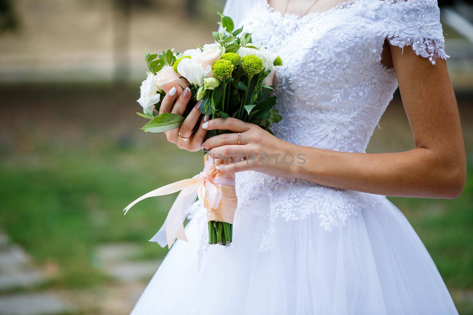 Beautiful wedding bouquet of flowers in the hands of the newlyweds