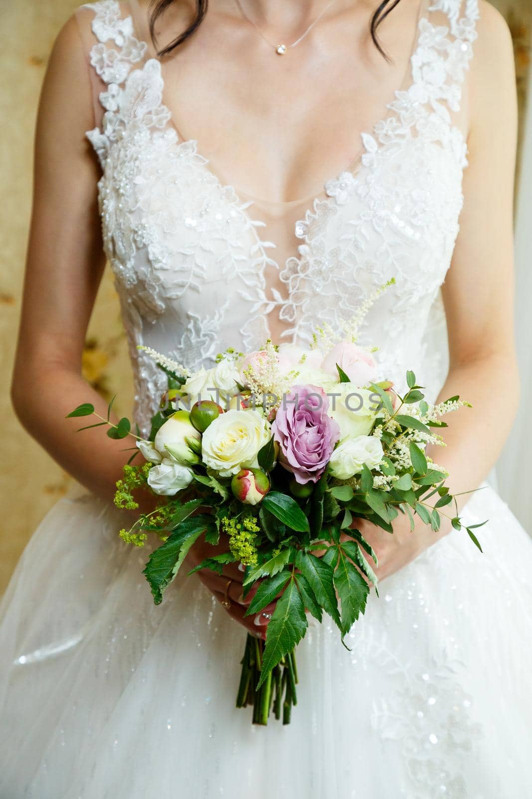 Beautiful wedding bouquet of flowers in the hands of the newlyweds