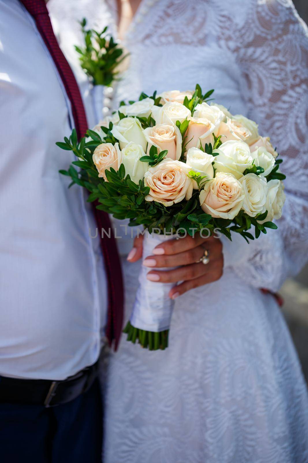 A bouquet of fresh flowers in the hands of the bride
