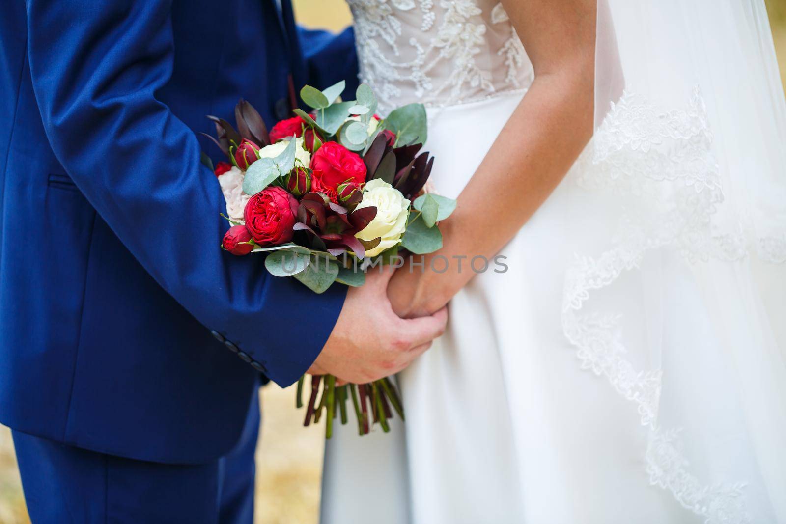 Beautiful wedding bouquet of flowers in the hands of the newlyweds