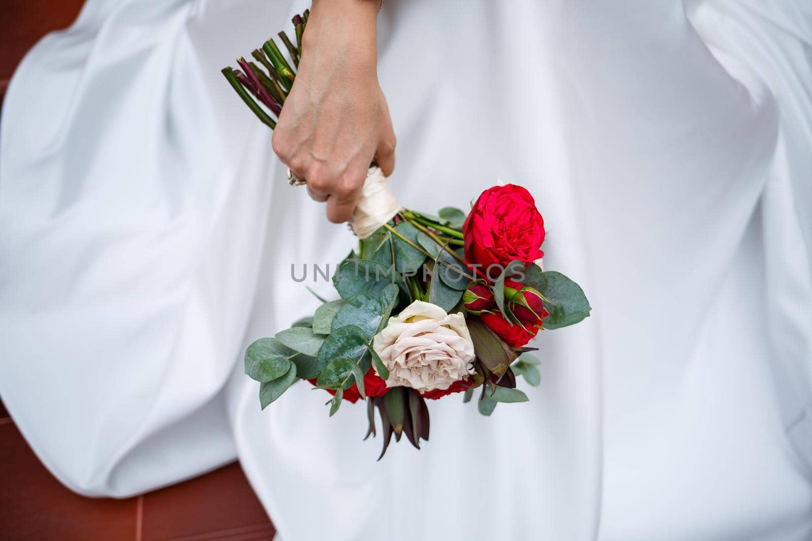 Beautiful wedding bouquet of flowers in the hands of the newlyweds