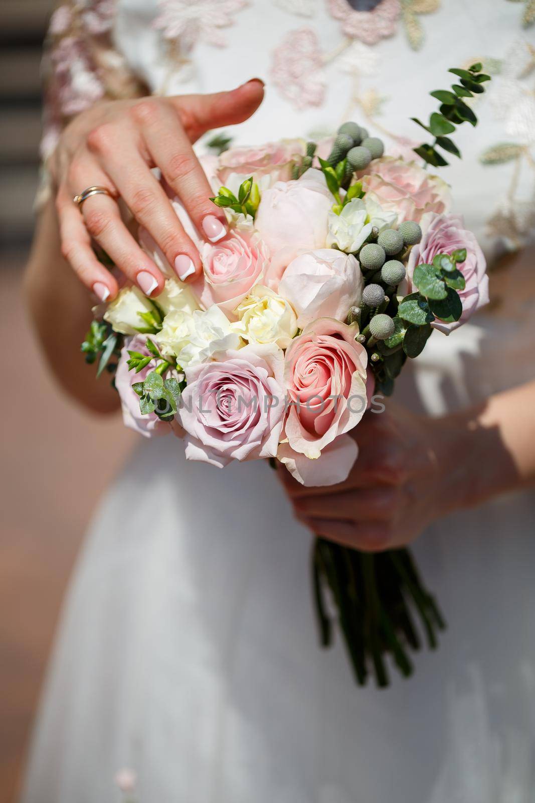 Beautiful wedding bouquet of flowers in the hands of the newlyweds