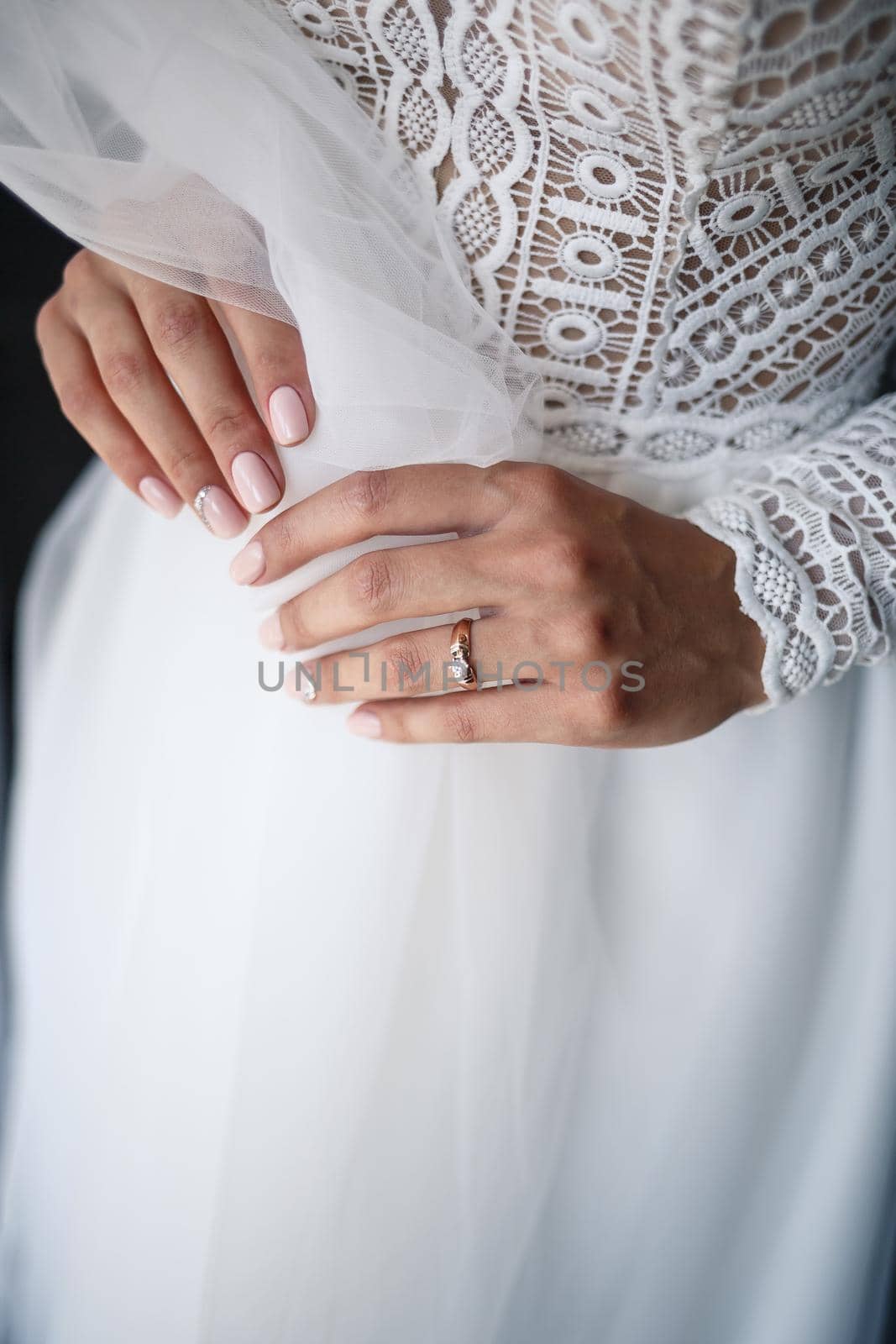 Gentle female hands of the bride with a gold wedding ring on the ring finger by Dmitrytph