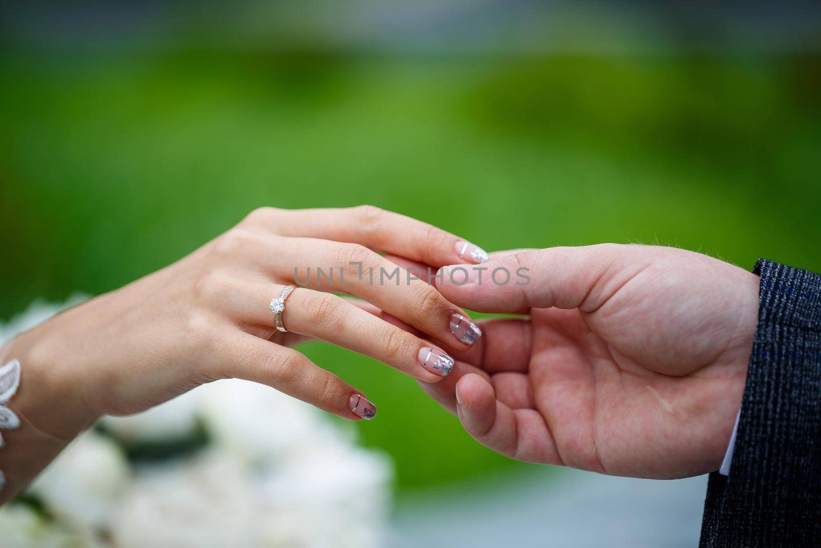 Gentle female hands of the bride with a gold wedding ring on the ring finger