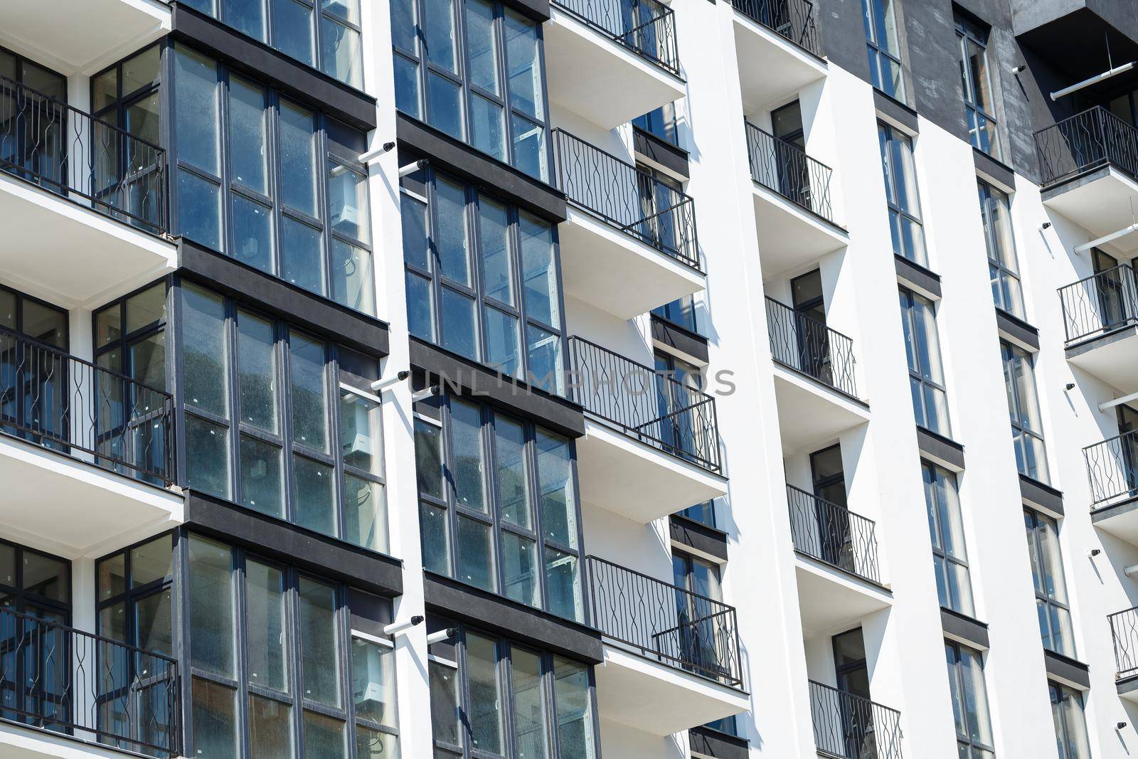 Large panoramic plastic windows. Facade of a new building in the house during construction work. Multi-storey building during construction