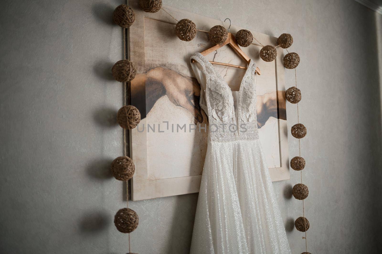 Ivory lace wedding long dress hanging on a wooden hanger