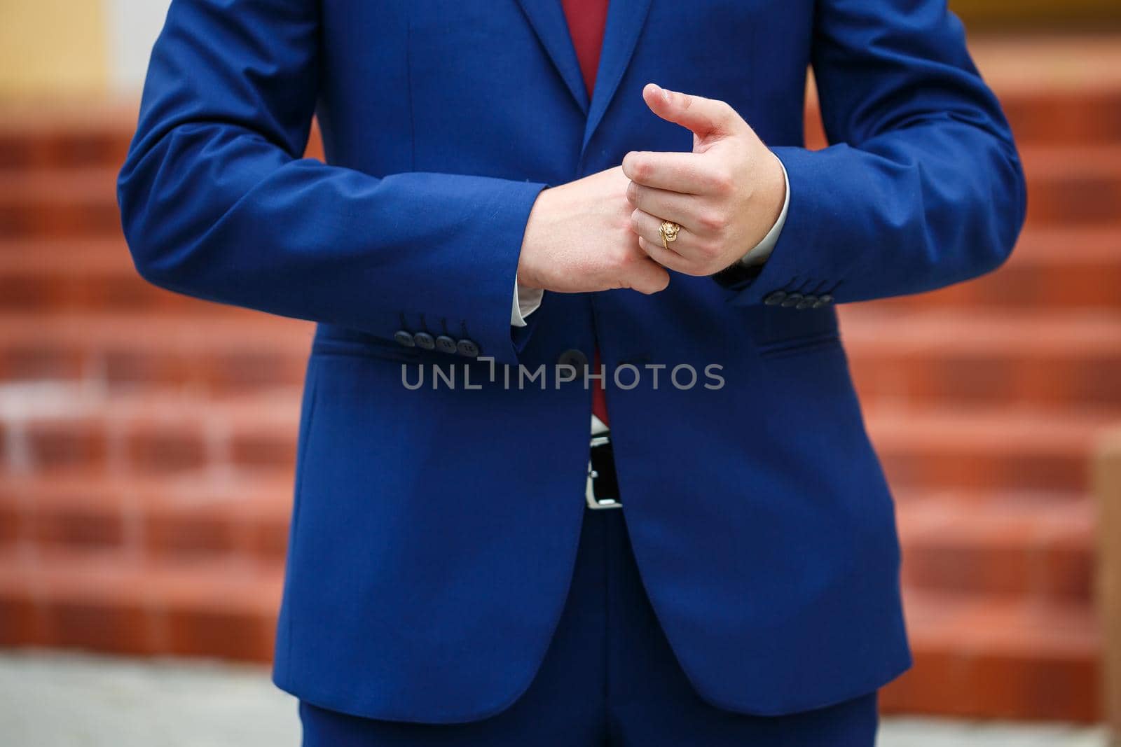 man puts on a suit on the wedding day