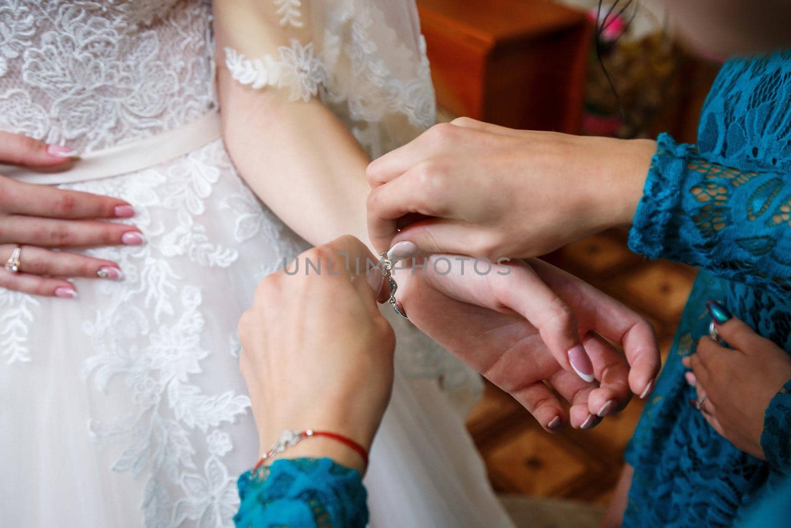 bride puts on wedding jewelry on the wedding day
