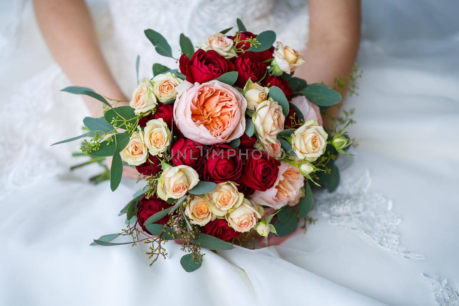 Beautiful wedding bouquet of flowers in the hands of the newlyweds