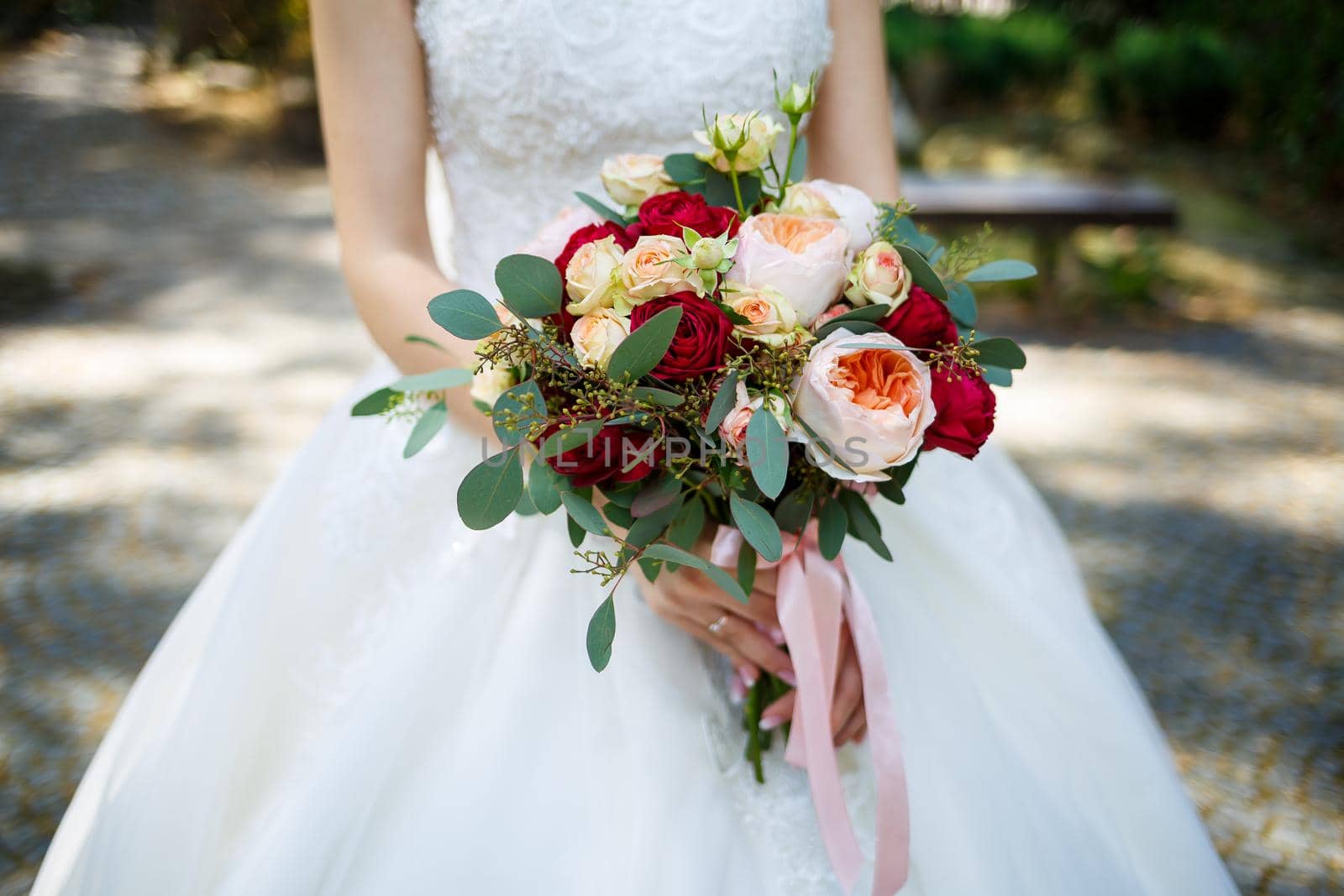 Beautiful wedding bouquet of flowers in the hands of the newlyweds