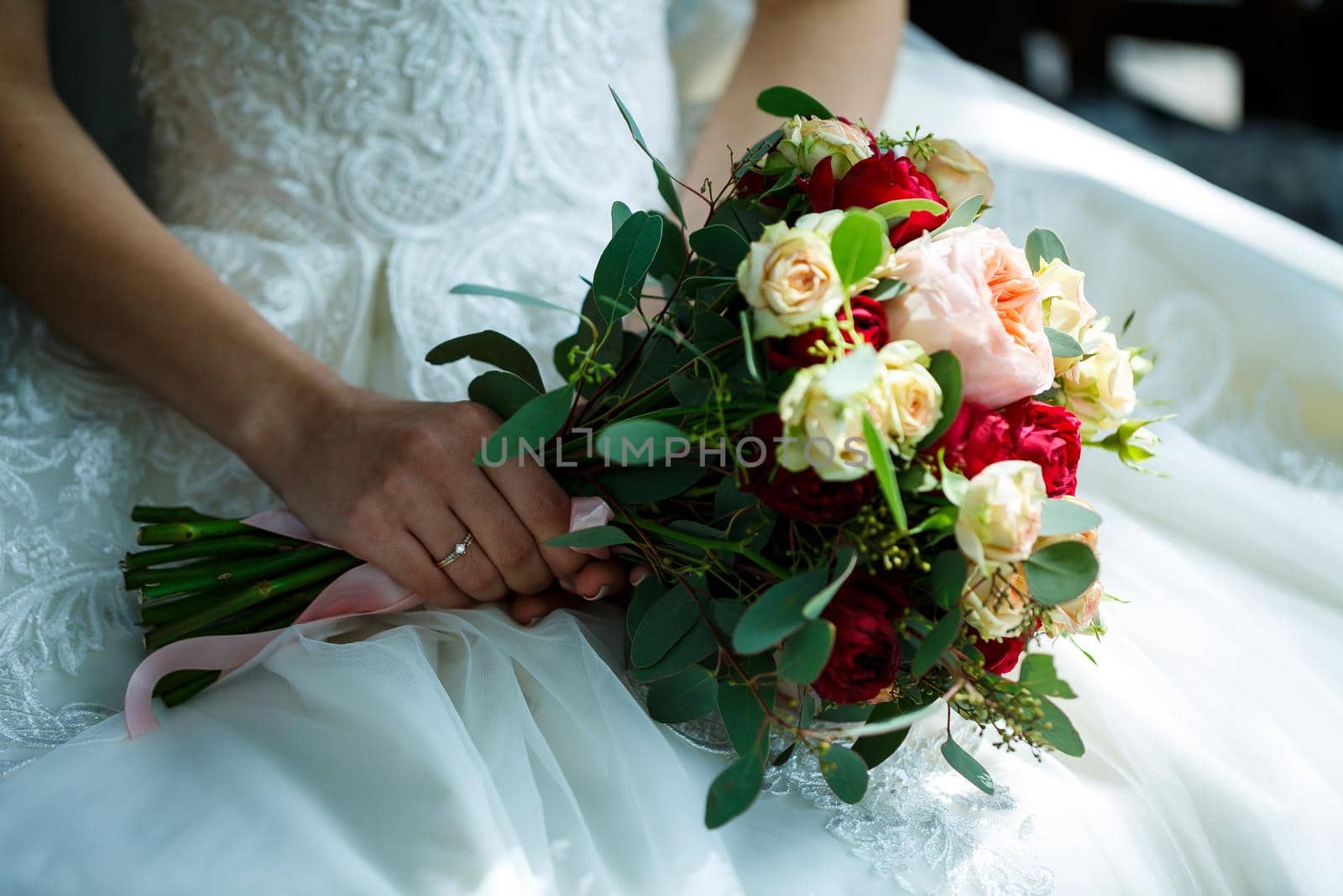 Beautiful wedding bouquet of flowers in the hands of the newlyweds