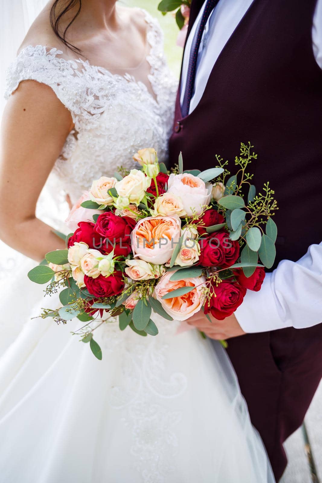 Beautiful wedding bouquet of flowers in the hands of the newlyweds