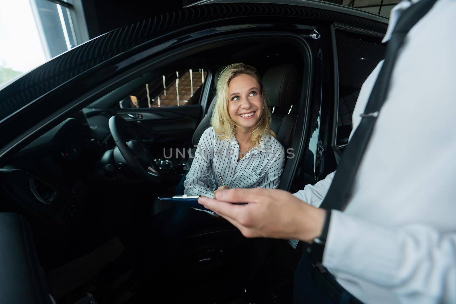 Happy caucasian woman signing a contract to buy a car