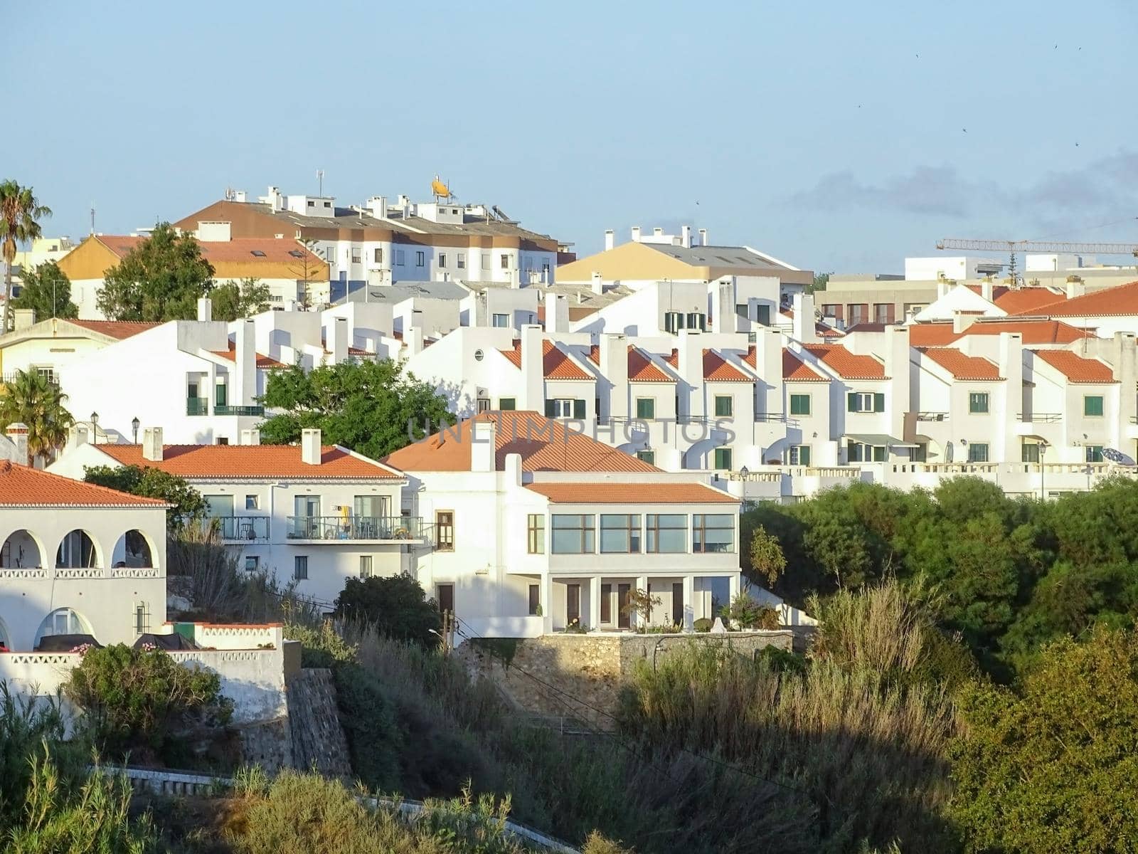 View of white houses with orange tiled roofs in the Portuguese coastal town Sines