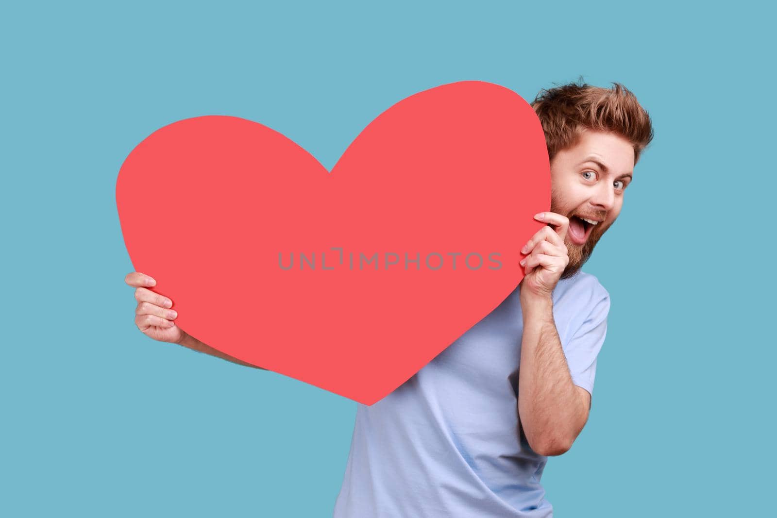 Man holding big read heart, looking at camera with excited facial expression, romantic feelings. by Khosro1