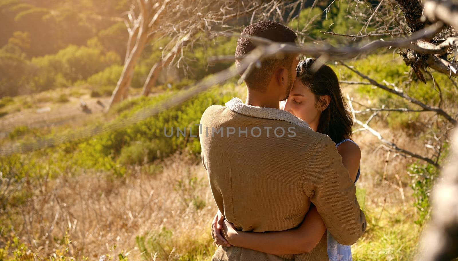 All we need is love. a young couple embracing one another on a date outside in nature. by YuriArcurs