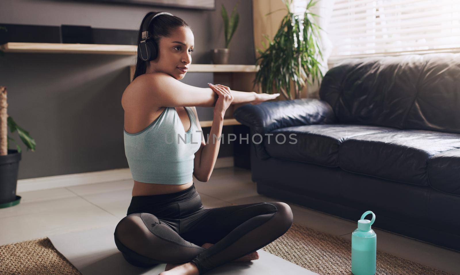 Its time to unwind your mind. a young female fitness trainer getting ready to live stream her workout at home. by YuriArcurs
