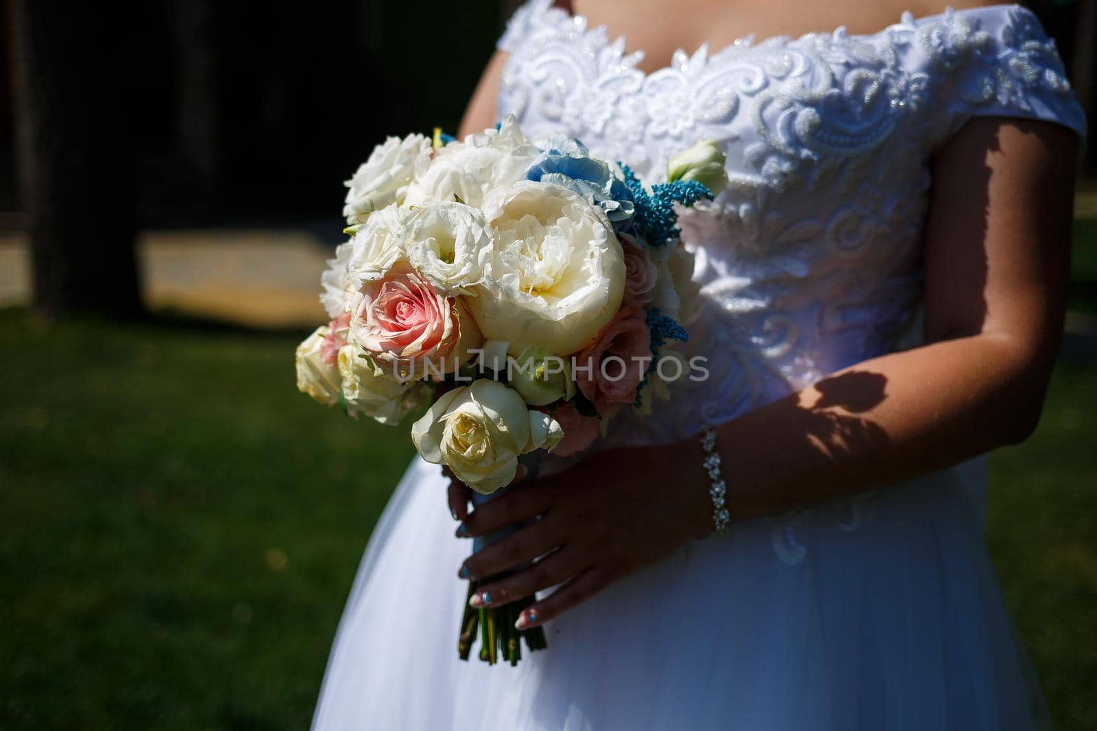 Beautiful wedding bouquet of flowers in the hands of the newlyweds