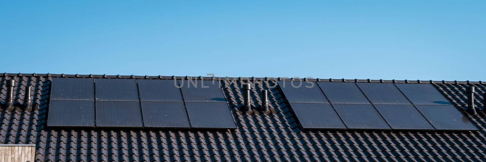 Newly build houses with solar panels attached on roof against a sunny sky Close up of solar pannel by fokkebok