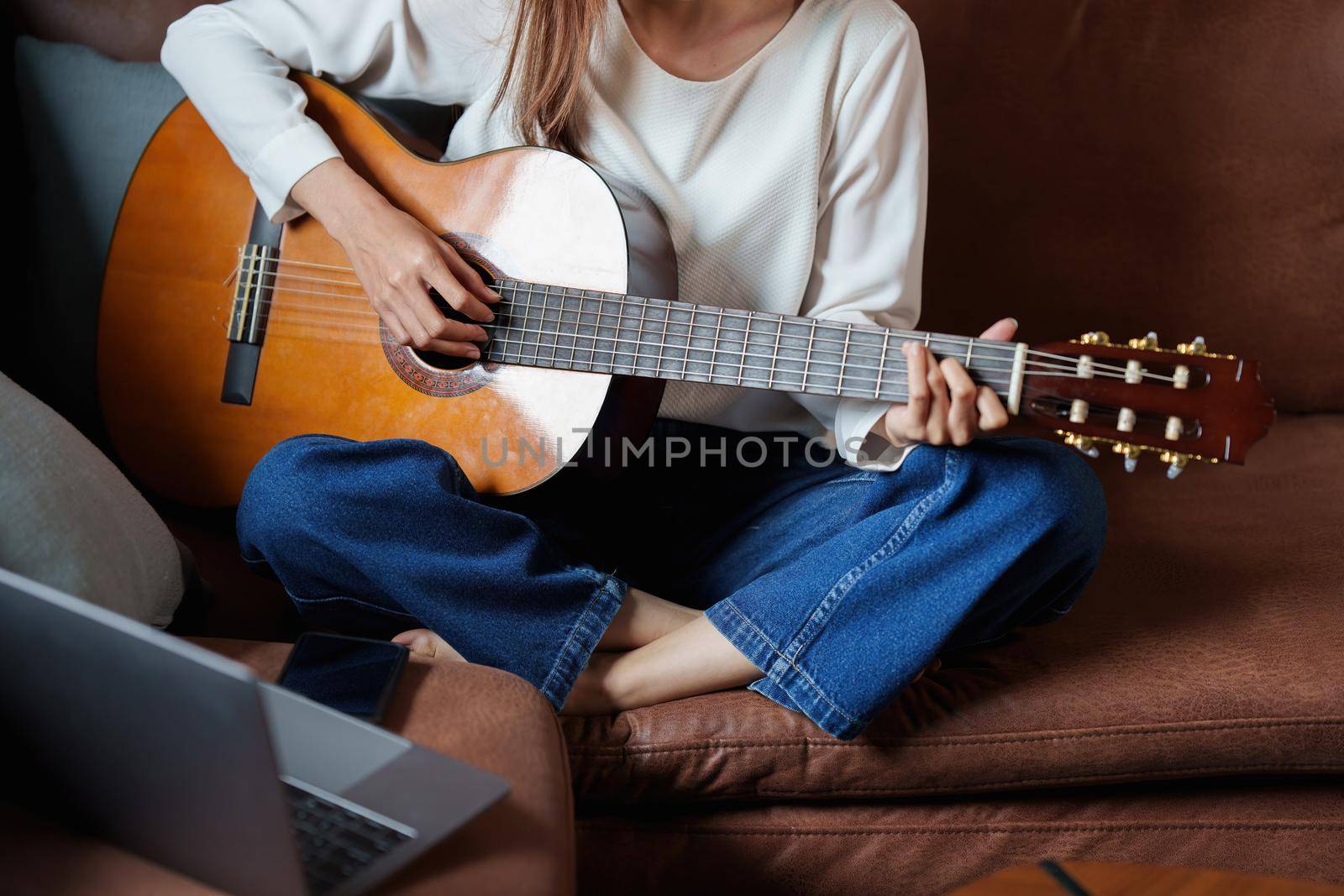 A beginner woman playing acoustic guitar lesson.