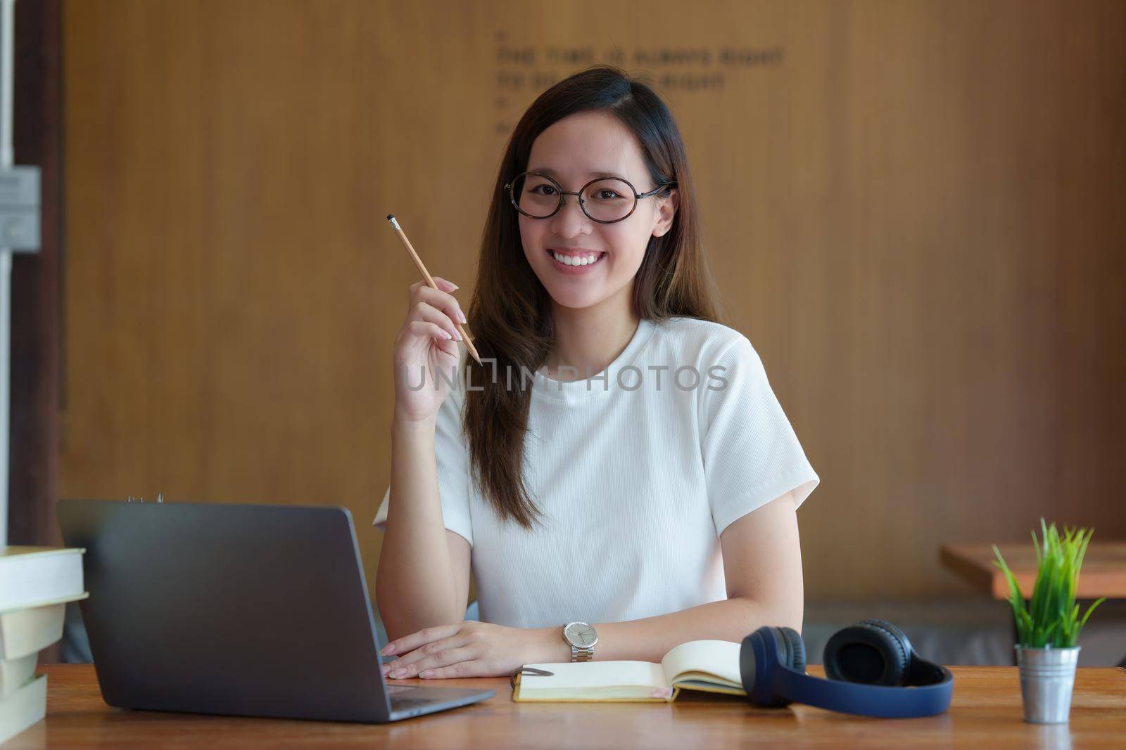 Back to school concept. Young college woman using laptop at library.