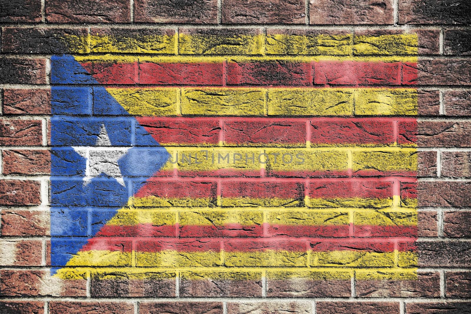 A Catalonia independence flag on brick wall background red yellow blue white star Estelada