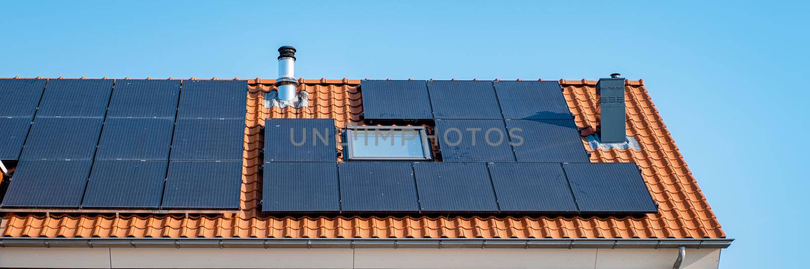 Newly build houses with solar panels attached on roof against a sunny sky Close up of solar pannel by fokkebok