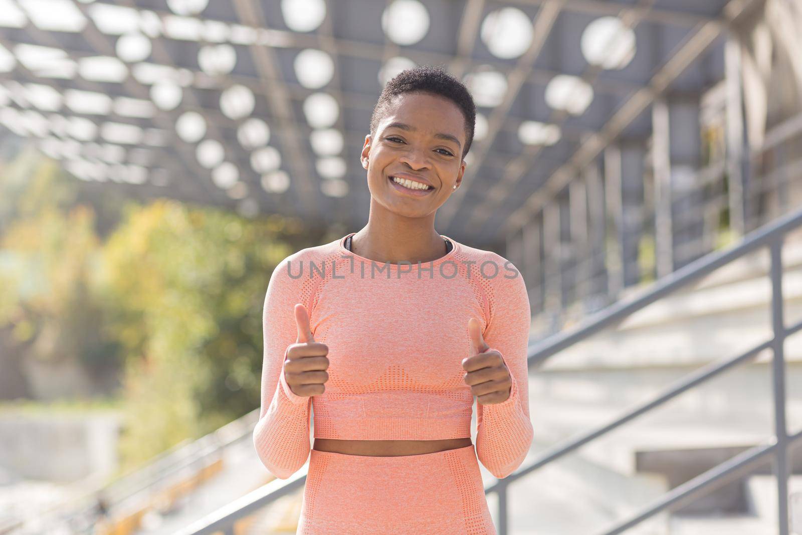 Young female athlete looks at the camera and smiles, stubborn and motivated fitness trenes encourages sports and active lifestyle