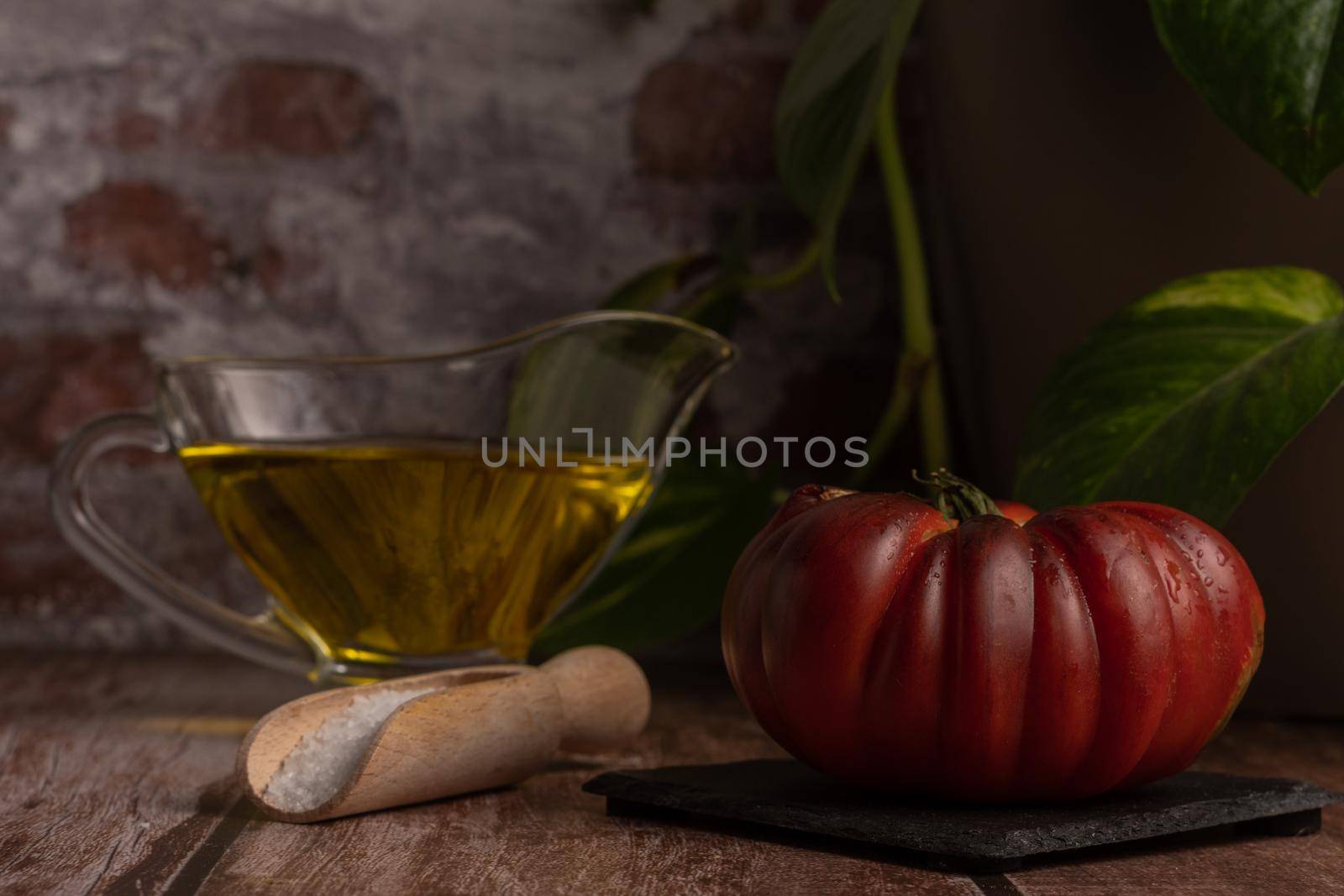chopped Moorish tomatoes with jar of olive oil and wooden spoon with salt