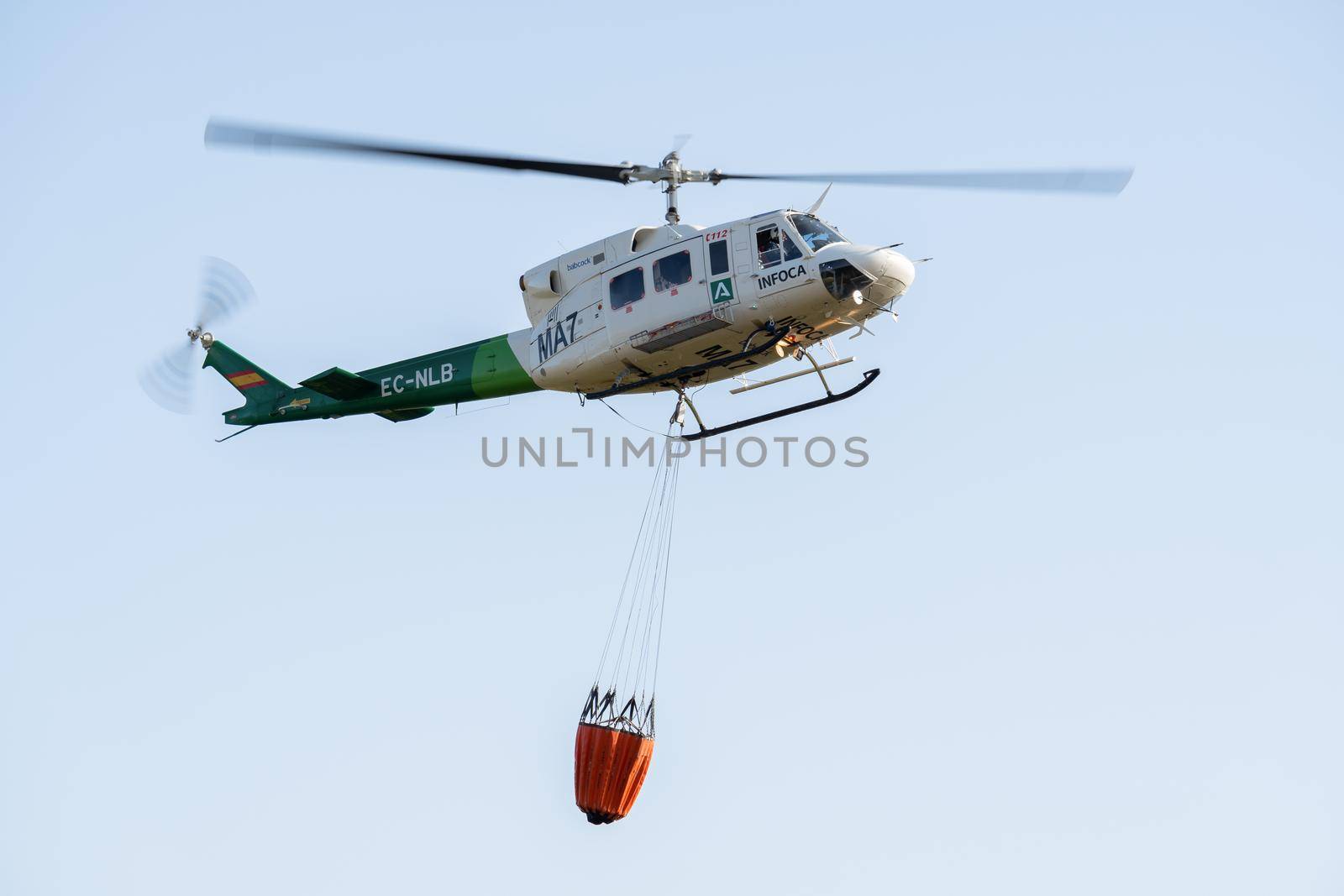 in-flight firefighting helicopter with water bag by joseantona