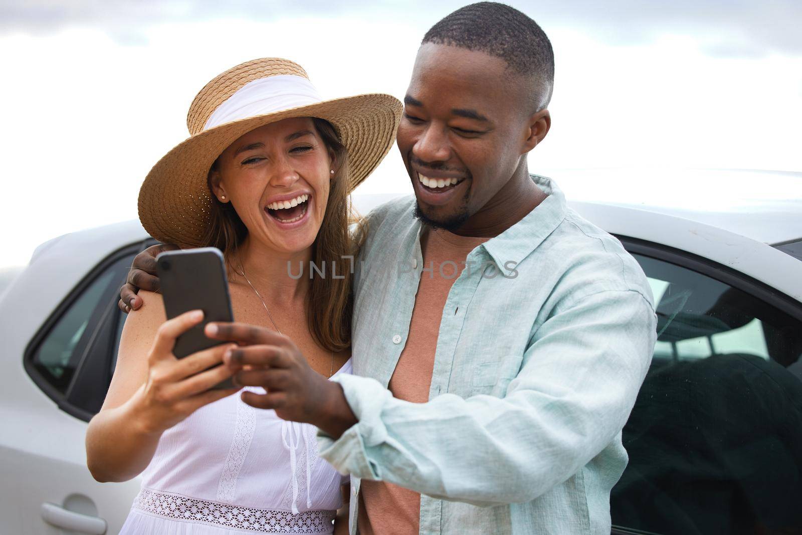 Travel gives you memories money could never buy. a happy young couple taking selfies on a road trip. by YuriArcurs