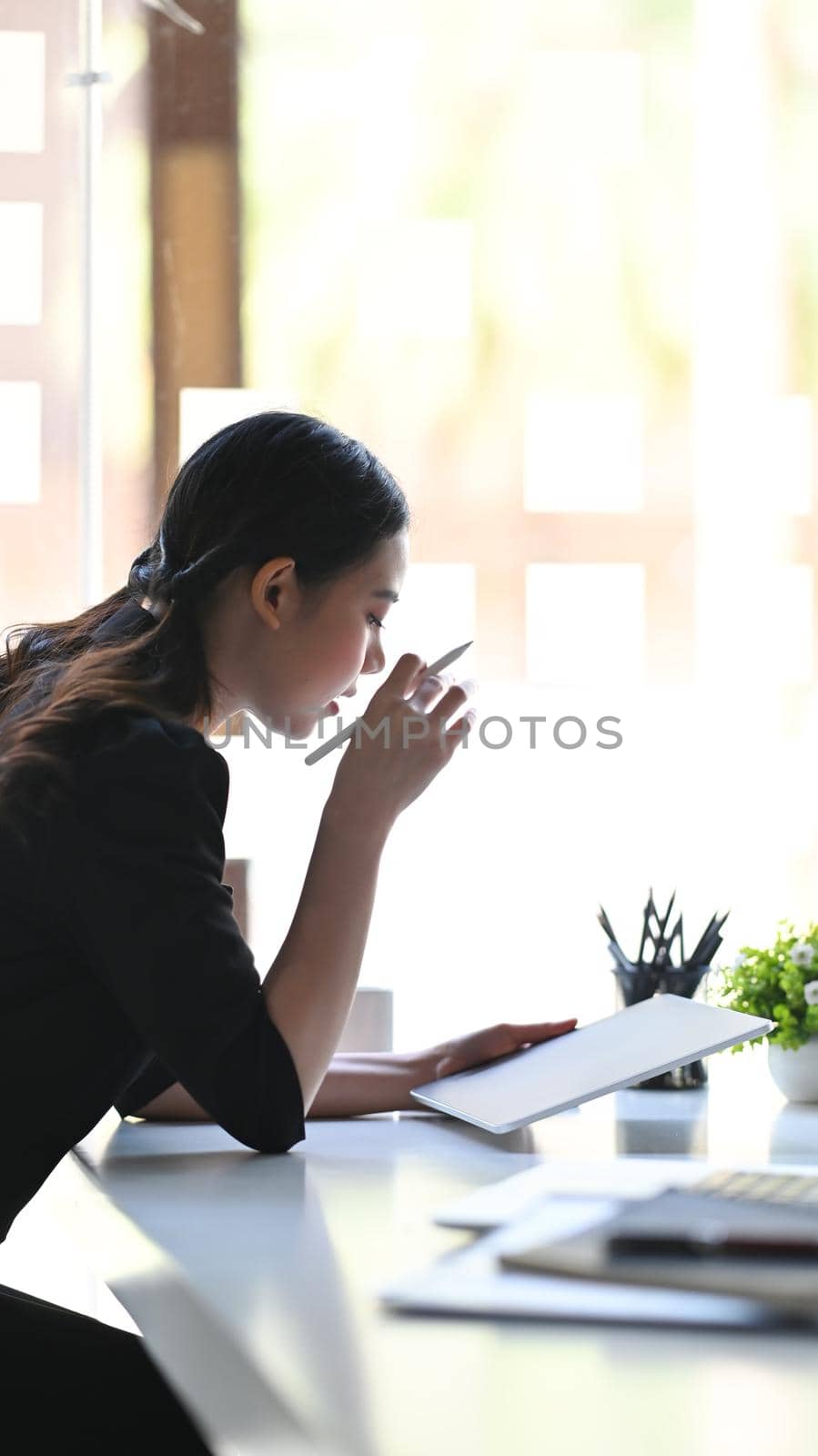 Side view businesswoman analyzing financial at a on digital tablet.