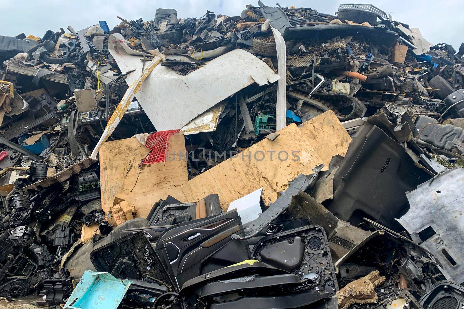 Piled up compressed cars going to be shredded, junk yard, many damaged old vehicles on car dump