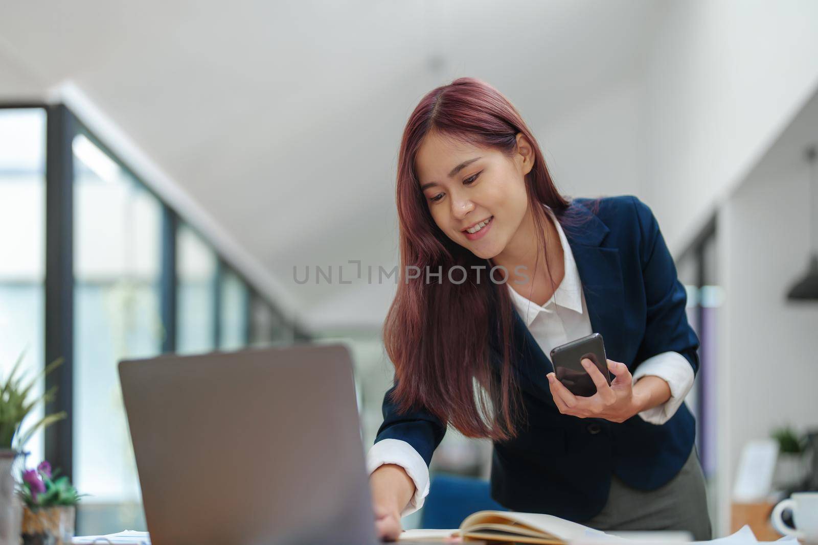 Asian businesswoman using the phone to contact a business partner.
