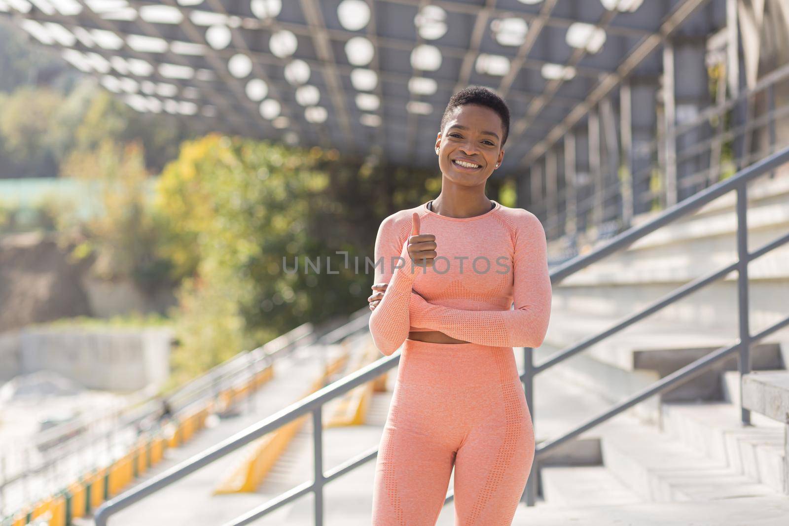 Young female athlete looks at the camera and smiles, stubborn and motivated fitness trenes encourages sports and active lifestyle