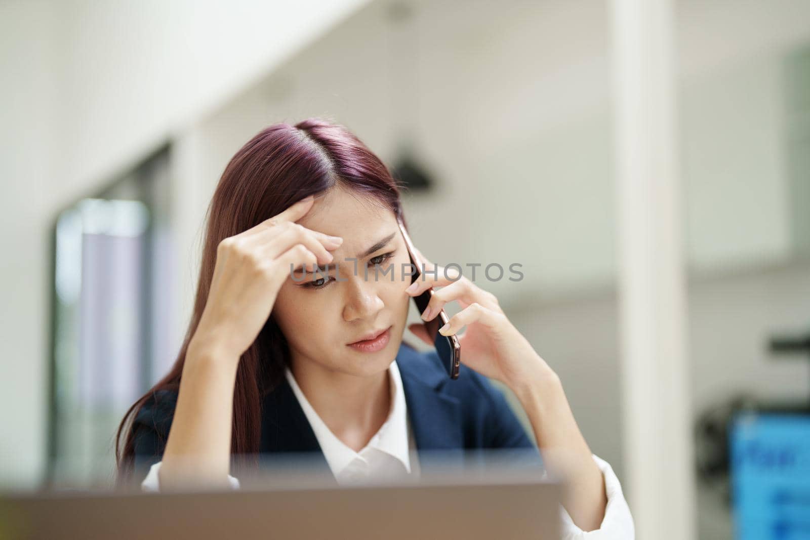 businesswoman showing a serious expression while talking on the phone.